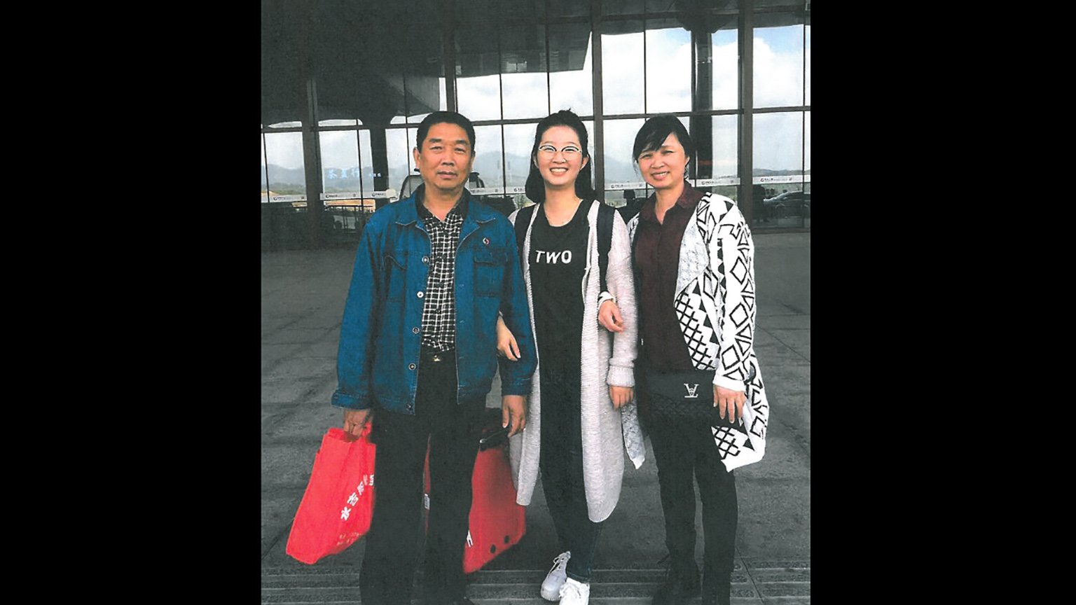 Yingying Zhang, center, stands with her parents at a train station in China in 2017. This marked the last time they saw their daughter alive. (U.S. Attorney's Office)