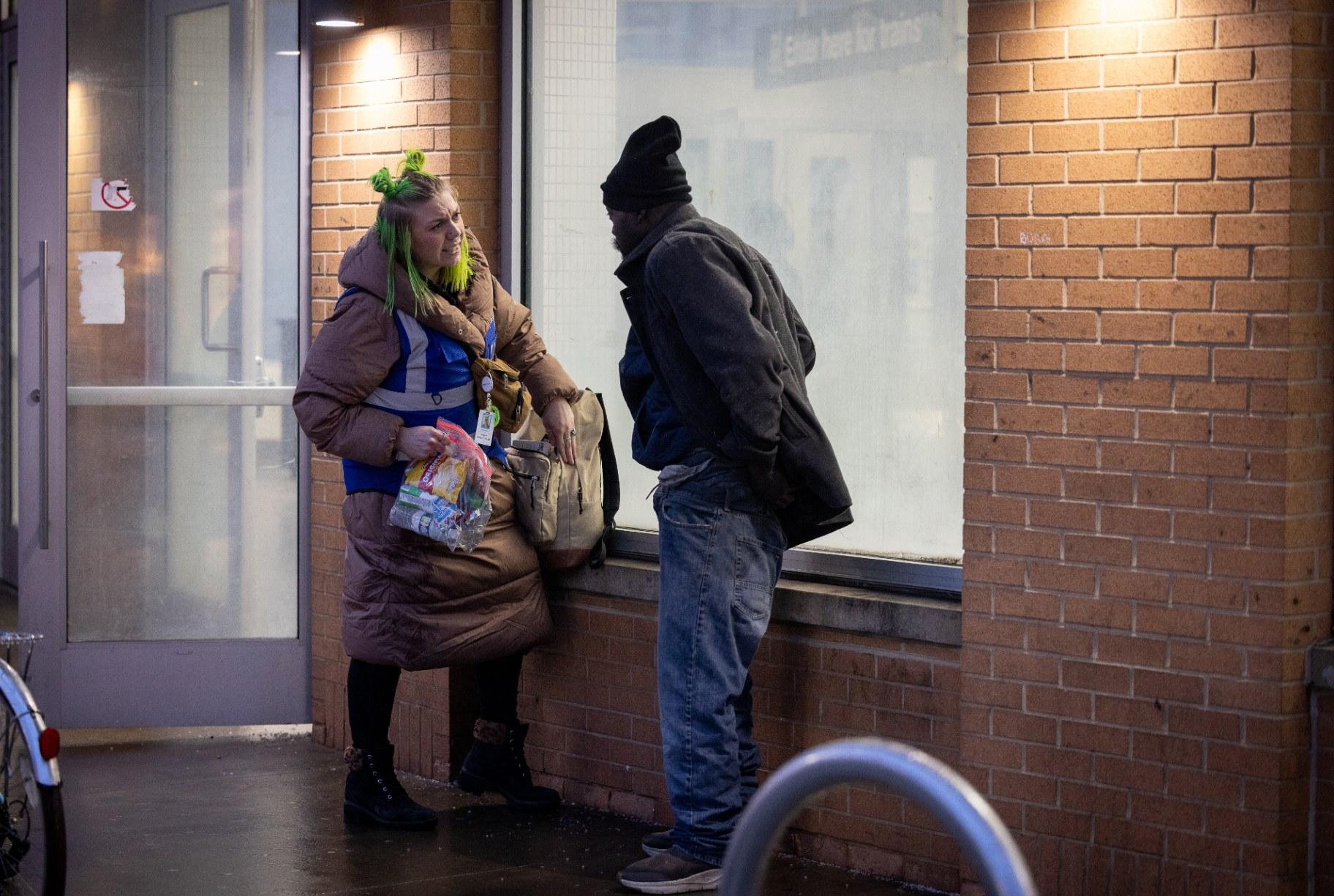 Caseworker Ell Fabricius talks to a person at the North/Clybourn Red Line stop about shelter options. (Kathleen Hinkel / Block Club Chicago)