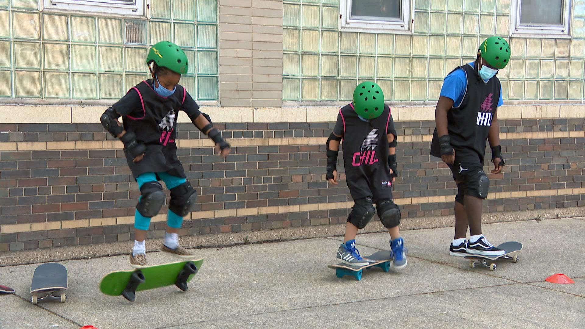 Toni A., left, flips her skateboard while receiving instruction from Temaris Dennis, right, the art instructor of the Louis L. Valentine Boys & Girls Club, on May 26, 2021. (WTTW News)