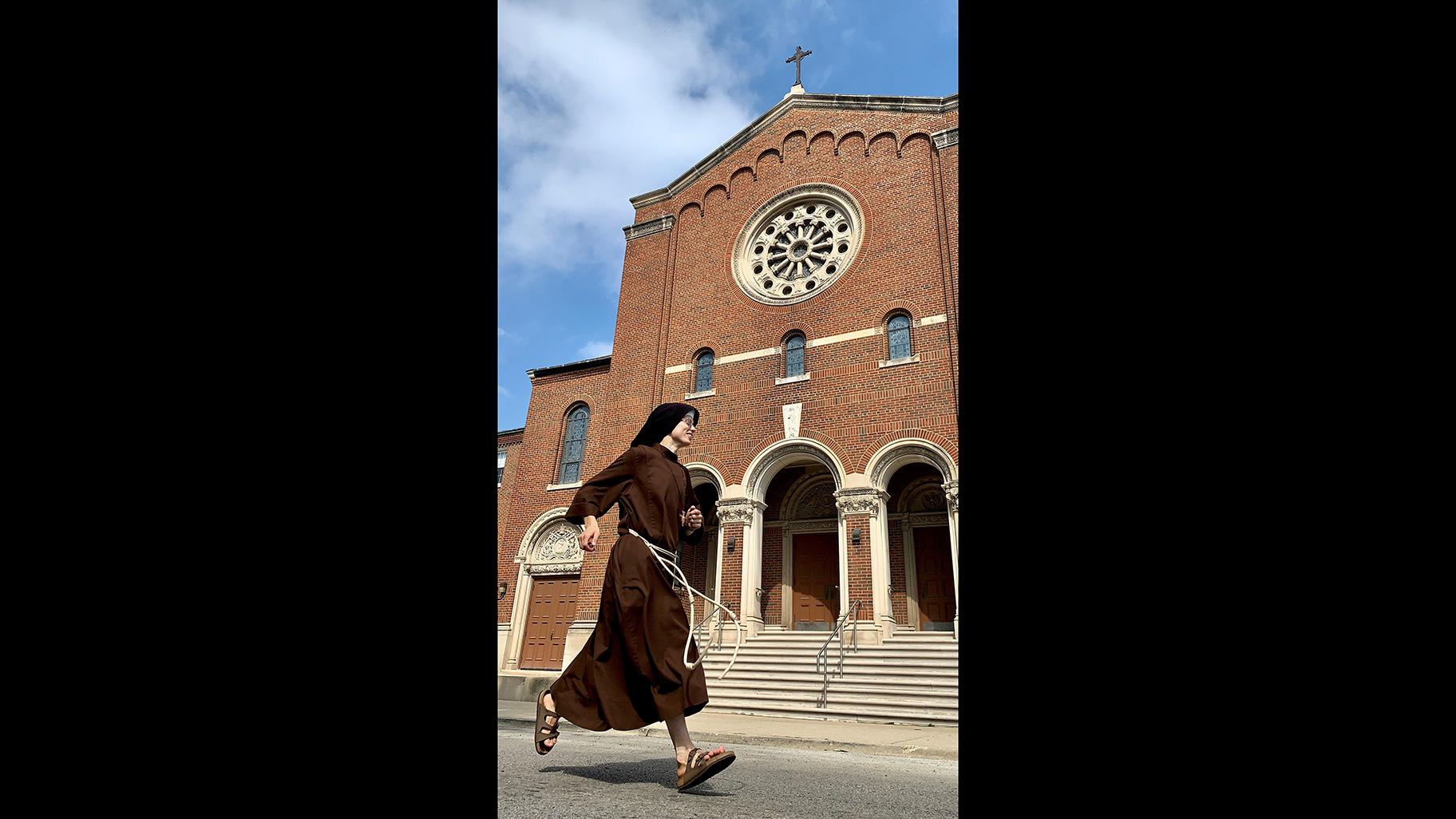 Sister Stephanie Baliga runs past the Our Lady of the Angels church in Chicago. (Jay Shefsky / 