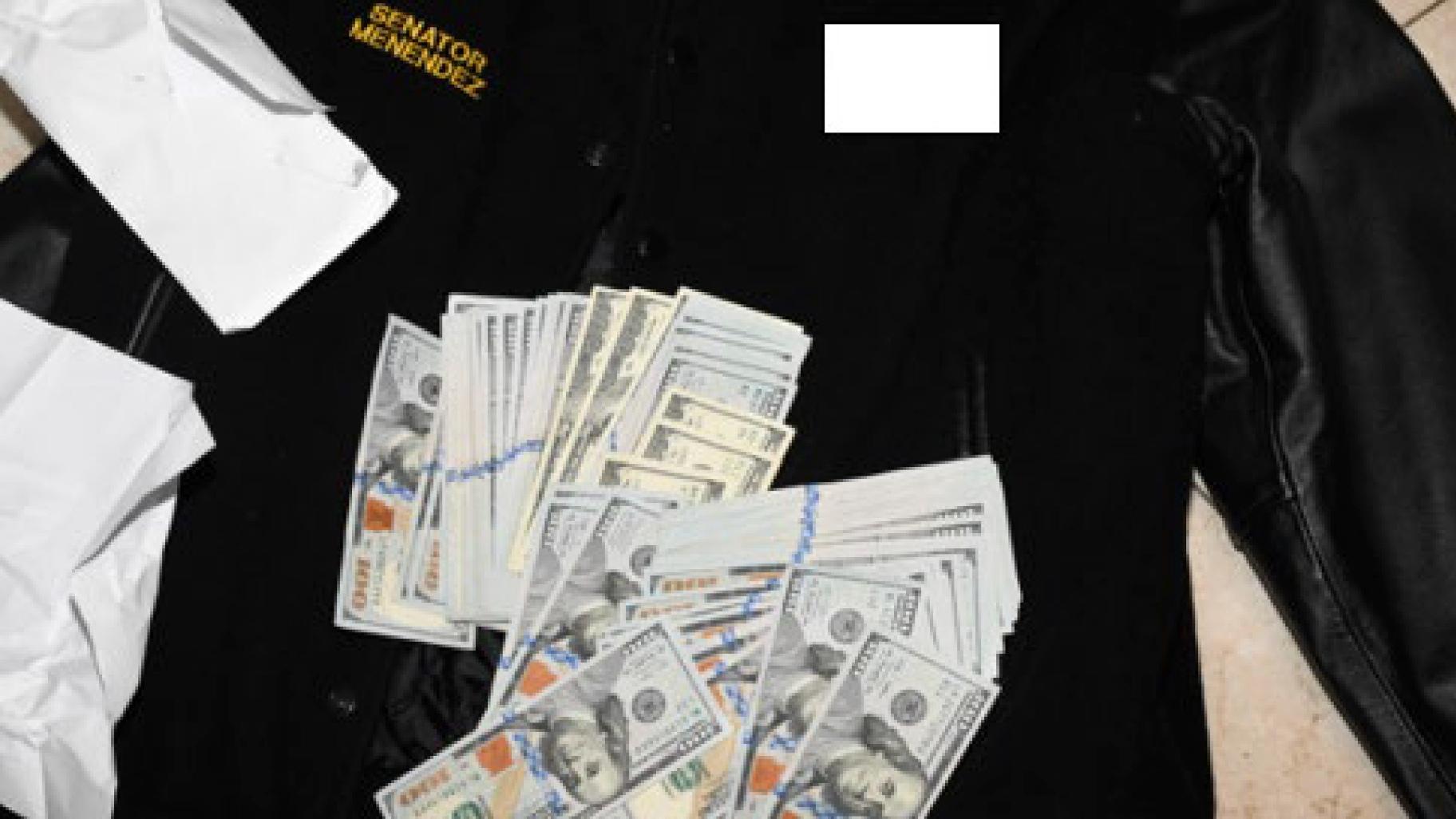 This photo, which was included in an indictment of U.S. Sen. Bob Menendez (D-N.J.), shows a jacket bearing Menendez’s name, along with cash from envelops found inside the Jacket during a search by federal agents of the senator's home in Harrison, N.J., in 2022. (U.S. Attorney’s Office via AP)