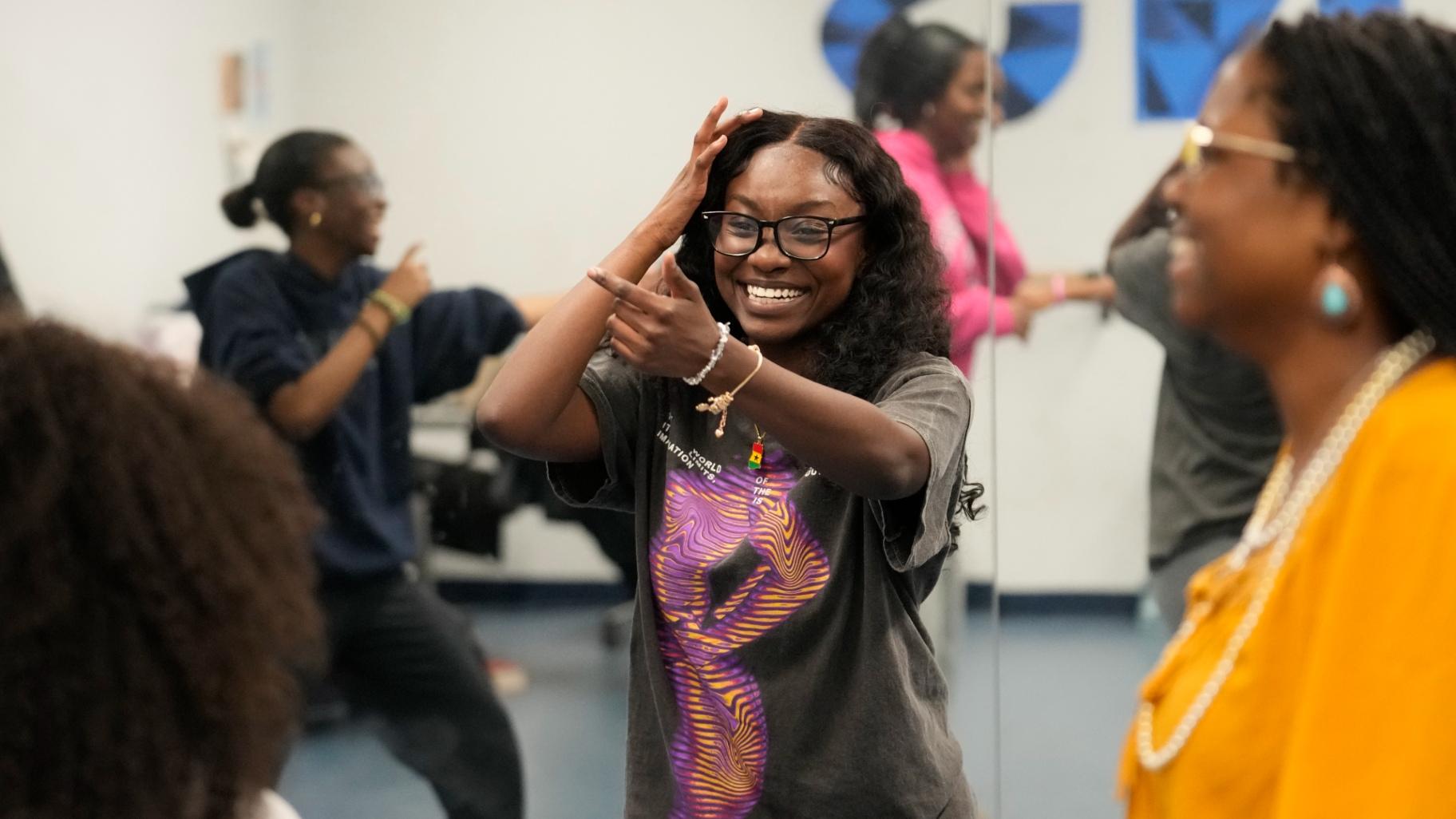 Hillary Amofa laughs as she participates in a team building game with members of the Lincoln Park High School step team after school Friday, March 8, 2024, in Chicago. (Charles Rex Arbogast / AP Photo)