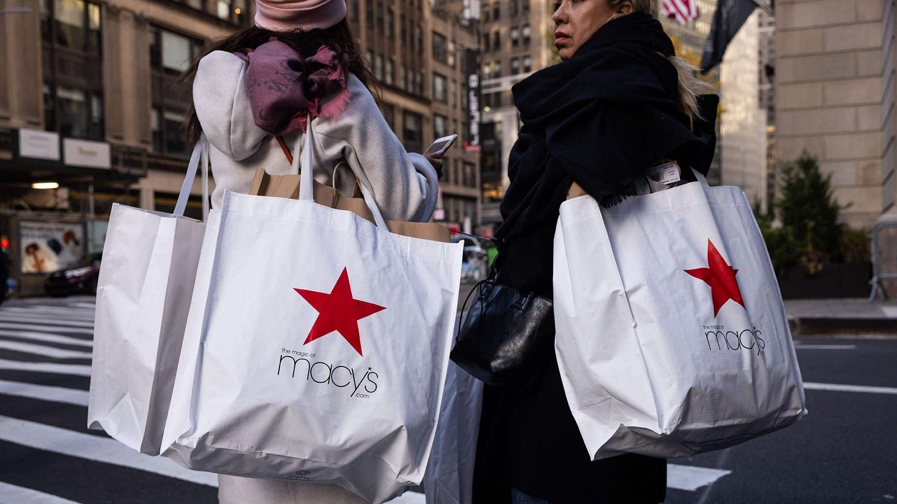 Shoppers carry Macy's bags during Black Friday in New York in November 2023. (Yuki Iwamura / AFP / Getty Images via CNN Newsource)
