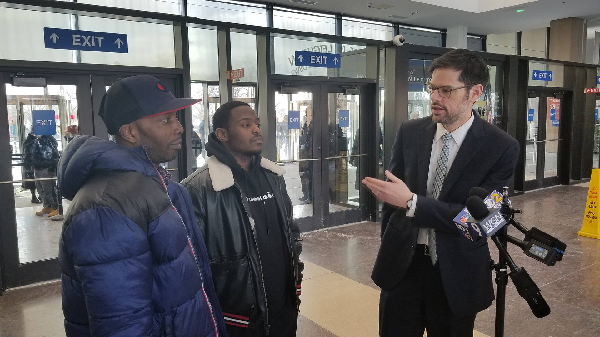 Attorney Joel Flaxman, right, stands inside the Leighton Criminal Court Building with Jermaine Coleman, center, and Germain Sims on Wednesday, Feb. 13, 2019. (Matt Masterson / Chicago Tonight)