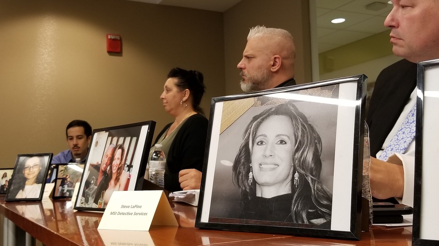 Members of Marni Yang's family and investigative team sit behind photos of Rhoni Reuter, who Yang was convicted of killing in 2007. (Matt Masterson / WTTW News)