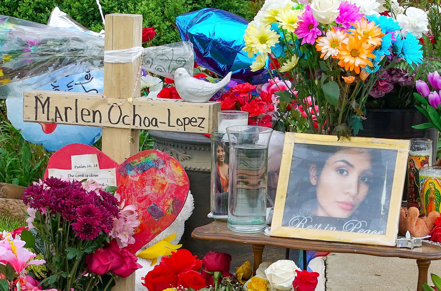 A memorial of flowers, balloons, a cross and photo of Marlen Ochoa-Lopez are displayed on the lawn, Friday, May 17, 2019 in Chicago, outside the home where Ochoa-Lopez was murdered last month. (AP Photo / Teresa Crawford)