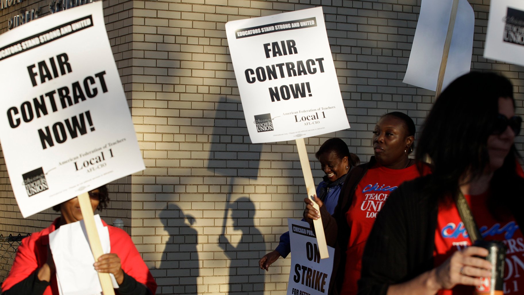 This Sept. 10, 2012 file photo shows Chicago teachers walking a picket line outside a school in Chicago, after they went on strike for the first time in 25 years. (AP Photo / M. Spencer Green, File)