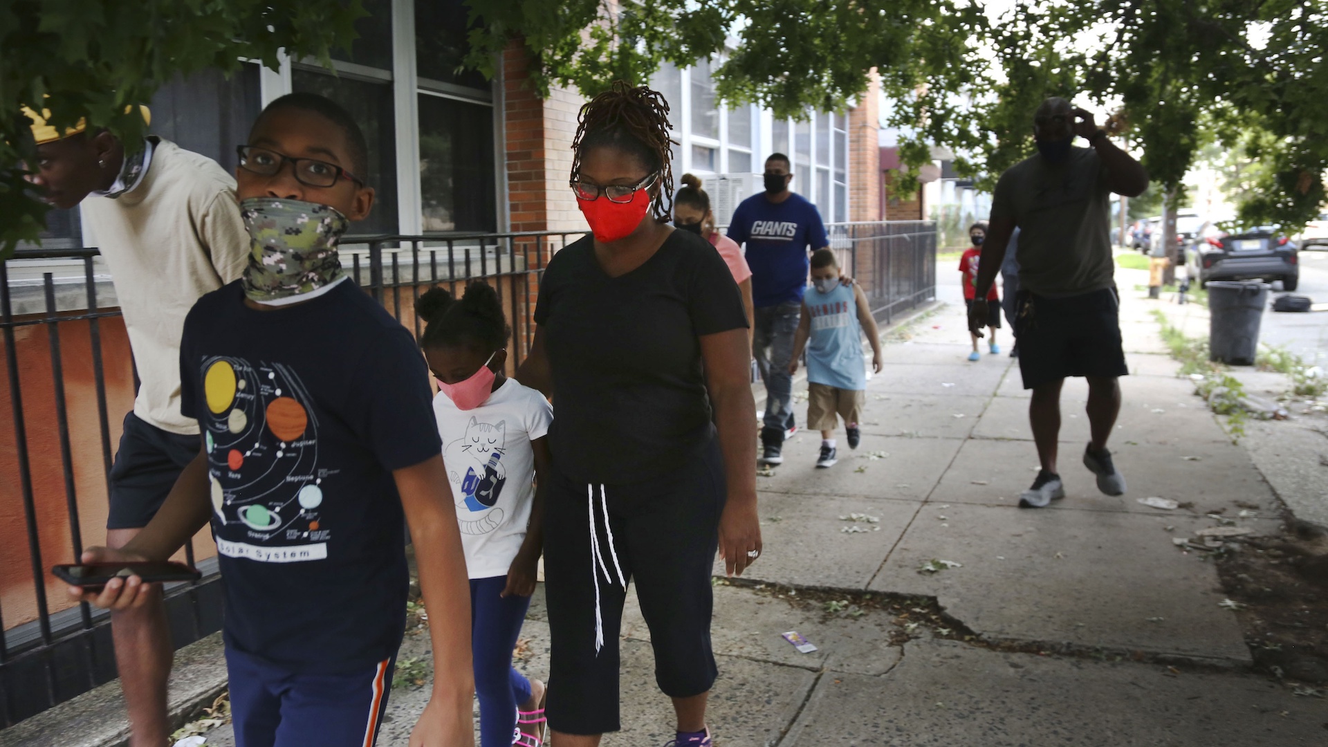 St. Francis Xavier School students and their families walk together in Newark, on Thursday, Aug. 6, 2020, after discussing the Catholic school's permanent closure announced the previous week by the Archdiocese of Newark. Nationwide, more than 140 Catholic schools will not reopen in the fall. (AP Photo/Jessie Wardarski)