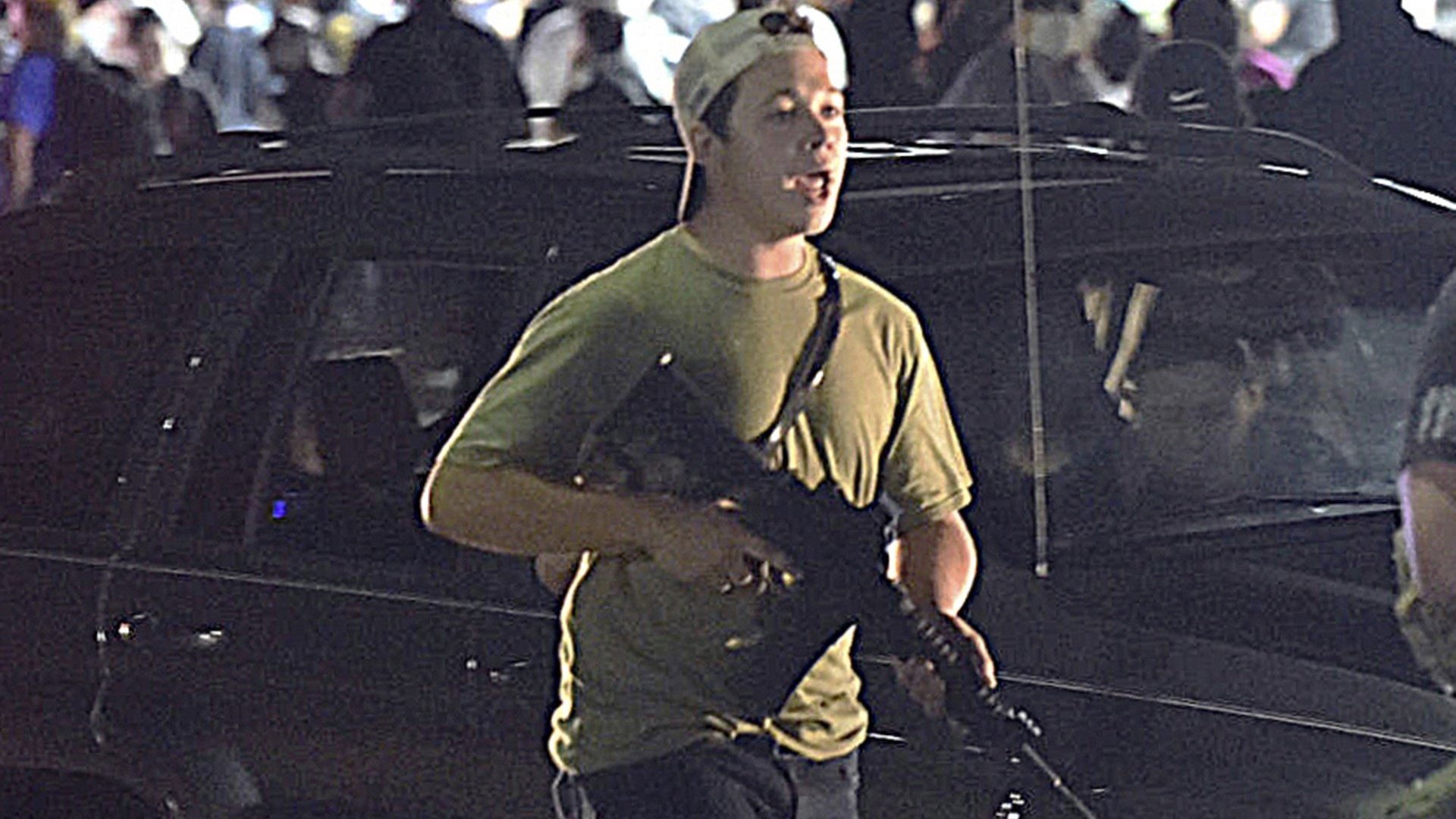 In this Tuesday, Aug. 25, 2020 file photo, Kyle Rittenhouse carries a weapon as he walks along Sheridan Road in Kenosha, Wis., during a night of unrest following the weekend police shooting of Jacob Blake. (Adam Rogan/The Journal Times via AP, File)
