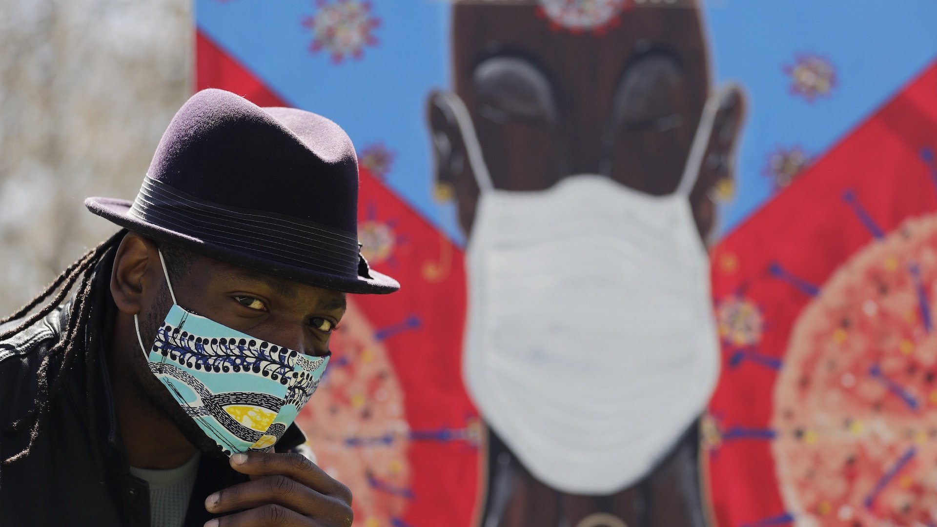 In this Tuesday, April 21, 2020 photo, Obi Uwakwe poses with his painting in Chicago. Uwakwe is an artist/photographer and submitted his art work to the the Illinois State Museum, which is documenting what daily life is like for Illinois families during the coronavirus pandemic. (AP Photo/Nam Y. Huh)