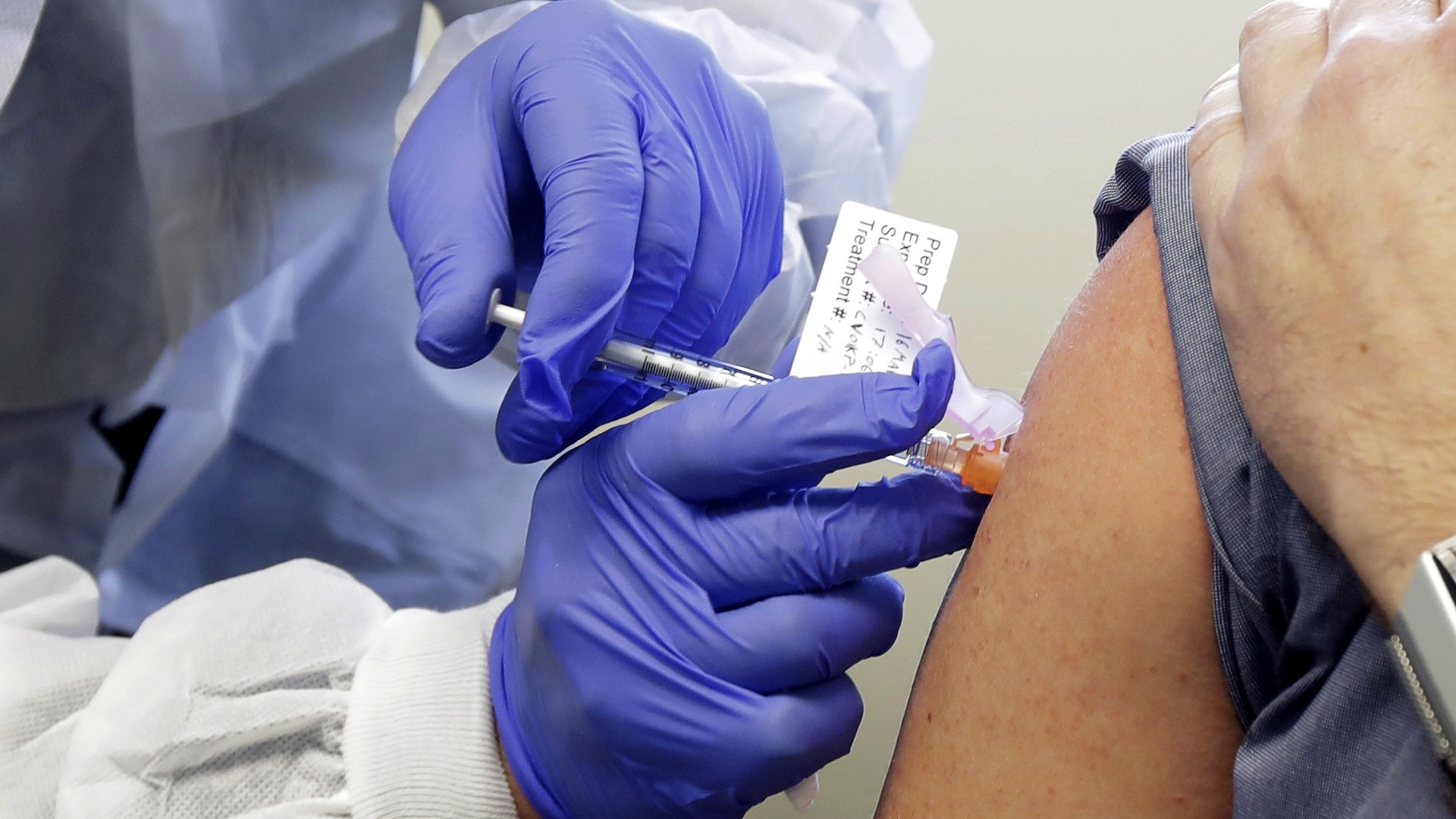In this March 16, 2020, file photo, a patient receives a shot in the first-stage safety study clinical trial of a potential vaccine for COVID-19, the disease caused by the new coronavirus, at the Kaiser Permanente Washington Health Research Institute in Seattle. (AP Photo/Ted S. Warren, File)