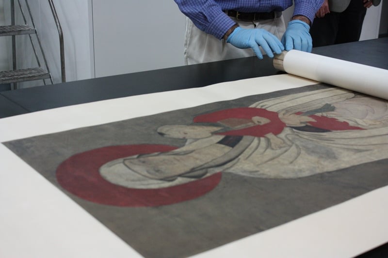 Unrolling of the Field Museum's Chinese Madonna scroll (Chloe Riley)