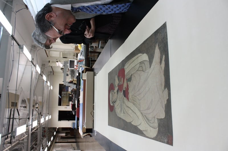 The Field's Deborah Bekken (left) and Gary Feinman stand over a rarely unveiled Chinese scroll. (Chloe Riley)