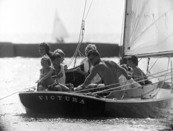 Robert F. Kennedy at the helm of <em>Victura</em>. Left to right: Maria Shriver, Courtney Kennedy, Bobby Shriver, Robert Kennedy Jr., Pat Prusyewski (a ward of the Shriver family), Robert F. Kennedy, David Kennedy, and Kathleen Kennedy. Photo courtesy of AP Photo/Bob Schutz, July 30 1961.