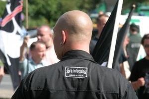 A neo-Nazi skinhead, whose shirt reads "White and Proud" in German.