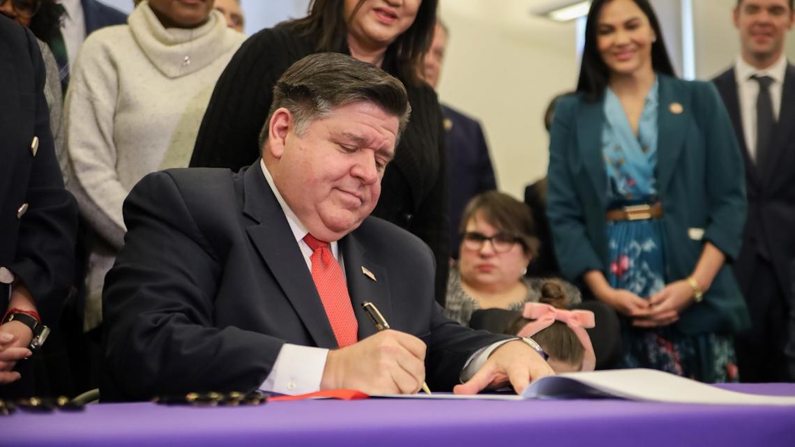 Gov. J.B. Pritzker signs the Dignity in Pay Act at a ceremony in Chicago on Tuesday, Jan. 21, 2025. (Andrew Adams / Capitol News Illinois)