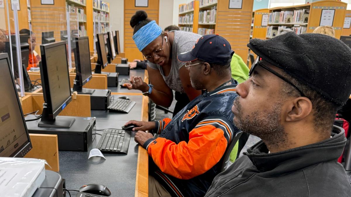 Adults served by Sertoma Star Services receiving assistance from a staff member at the Alsip-Merrionette Park Library during the fall of 2024. (Photo courtesy of Sertoma Star Services)