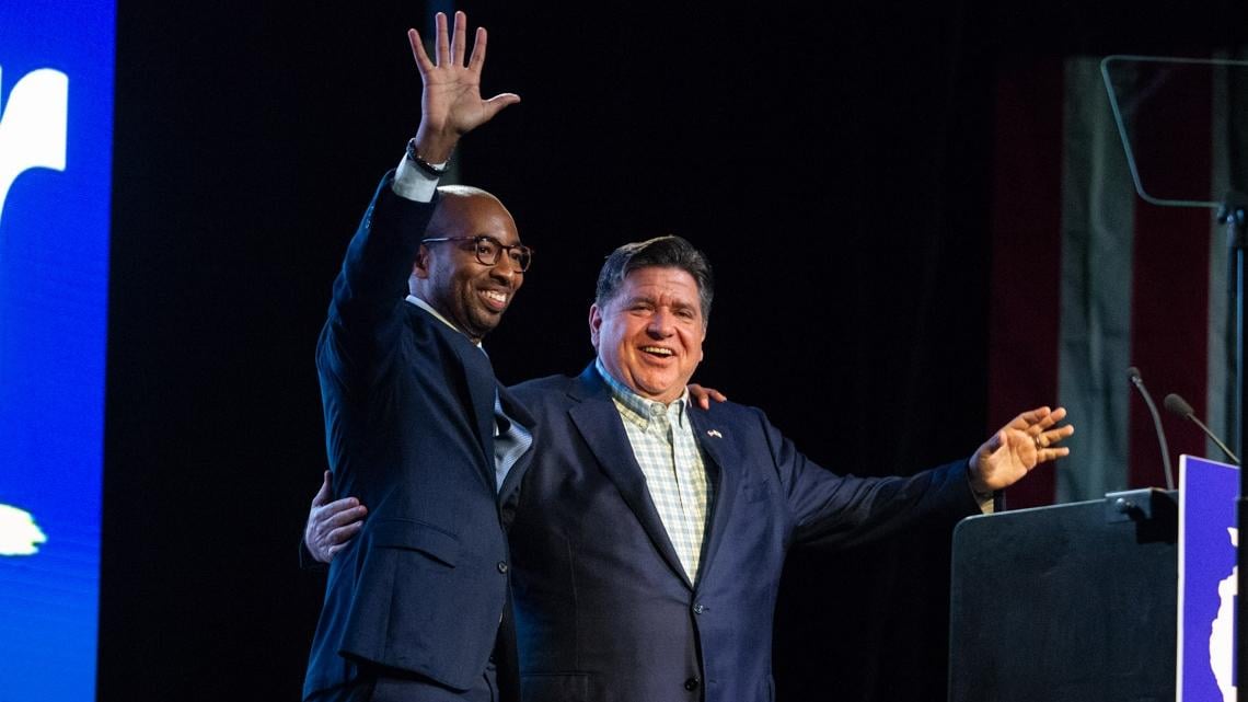 Gov. JB Pritzker, right, is joined by his running mate Christian Mitchell on stage at the Illinois Democratic County Chairs’ Association brunch in Springfield on Aug. 19, 2026.  (Jerry Nowicki / Capitol News Illinois)