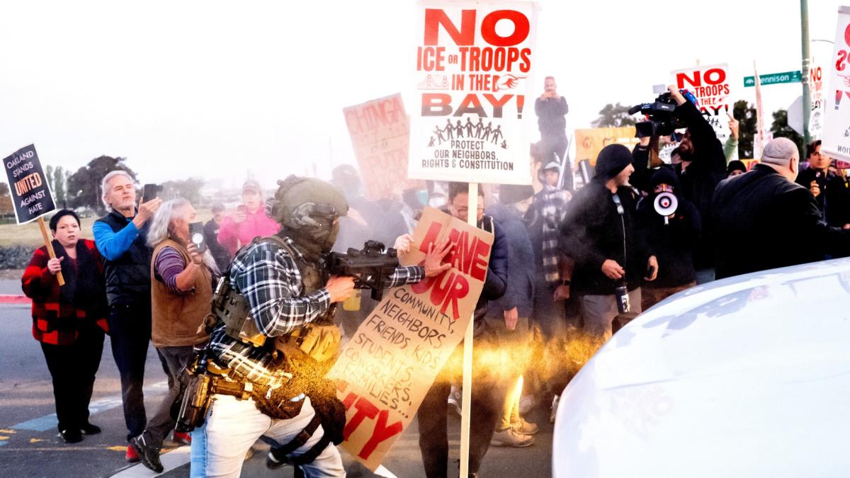 A person pushes a protester blocking a caravan of U.S. Customs and Border Protection personnel trying to enter Coast Guard Base Alameda on Thursday, Oct. 23, 2025, in Oakland, Calif. (AP Photo / Noah Berger)