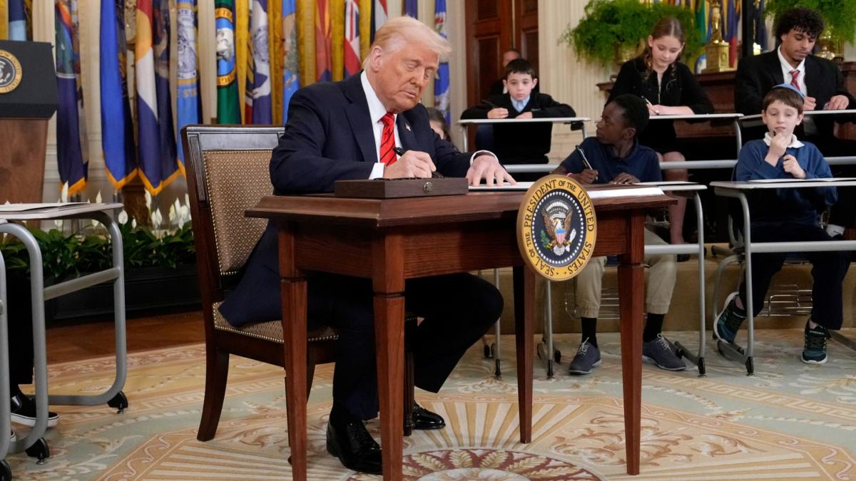 President Donald Trump signs an executive order in the East Room of the White House in Washington, Thursday, March 20, 2025. (AP Photo / Ben Curtis)