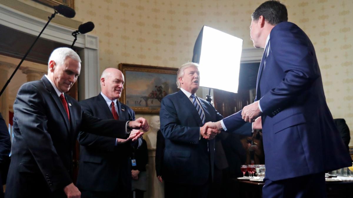 Vice President Mike Pence, left, and Secret Service Director Joseph Clancy stand as President Donald Trump shakes hands with FBI Director James Comey during a reception for inaugural law enforcement officers and first responders in the Blue Room of the White House, Jan. 22, 2017 in Washington. (AP Photo / Alex Brandon, File)