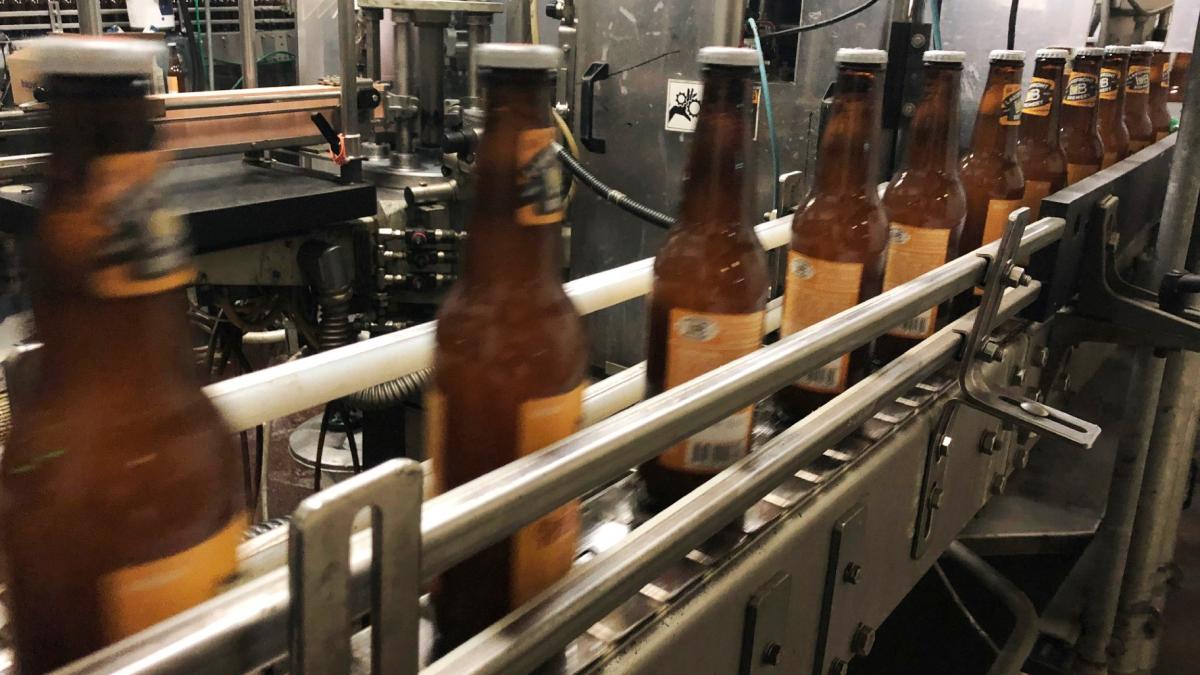 FILE- Bottles freshly filled with beer move on a conveyor belt at Lakefront Brewery in Milwaukee, Jan. 14, 2019. (Carrie Antlfinger / AP Photo, File)