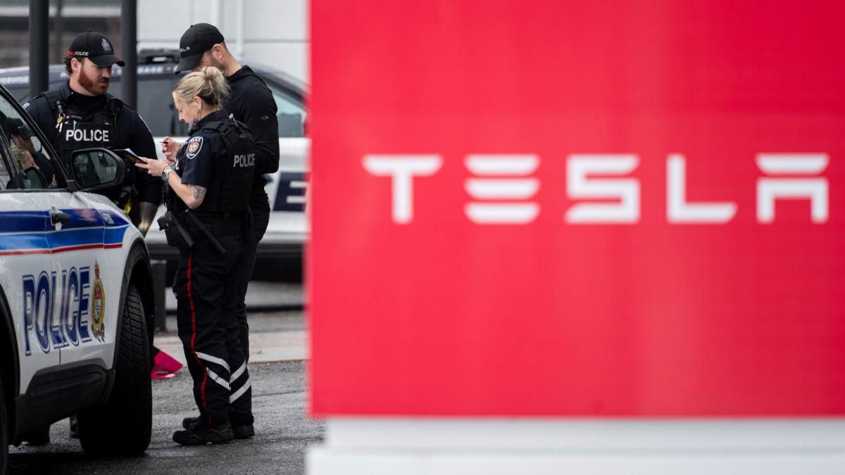 Officers from Ottawa Police Service (OPS) are seen at a Tesla Service and Showroom centre after it was damaged with pink spray paint in Ottawa, on Monday, March 31, 2025. (Spencer Colby / The Canadian Press via AP)