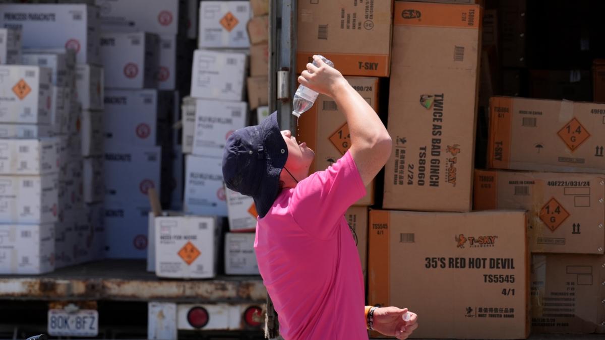 Wyatt Seymore pours the last drops of liquid from a water bottle into his mouth as he takes a break from unloading a stiflingly hot trailer of fireworks outside Powder Monkey Fireworks ahead of the opening of the stand, June 17, 2024, in Weldon Spring, Mo. (AP Photo / Jeff Roberson, File)