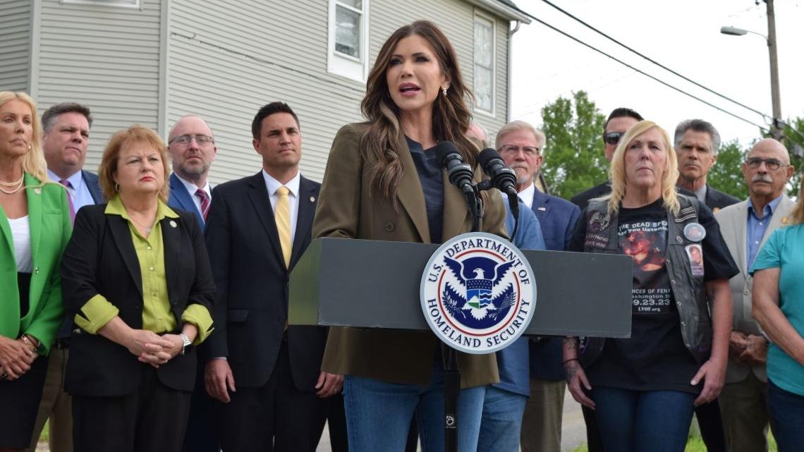 DHS Secretary Kristi Noem speaks in front of a house in the neighborhood where progressive activist Emma Shafer, a Springfield woman who was killed in 2023, allegedly by her boyfriend, who was from Mexico. She is joined by Republican lawmakers and family members of people identified as crime victims. (Jade Aubrey / Capitol News Illinois)