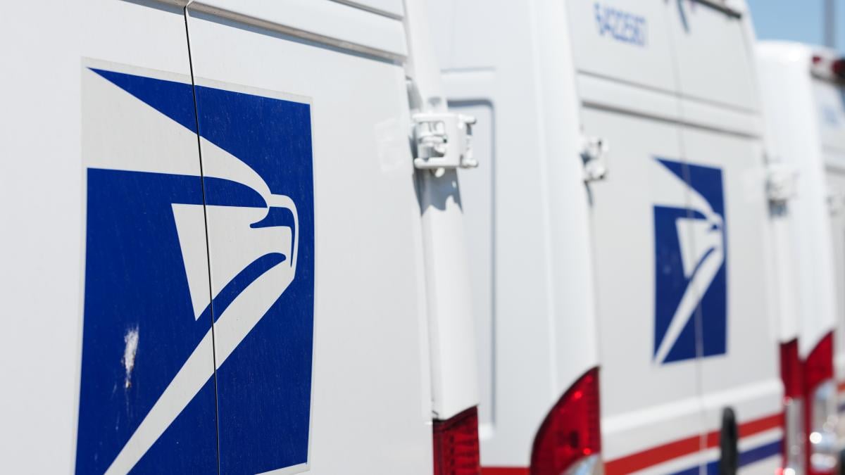 Delivery vans bearing the logo sit during a protest staged as part of a countrywide National Day of Action Tuesday, July 28, 2026, outside the main United States Postal Service headquarters in northeast Denver. (AP Photo / David Zalubowski)