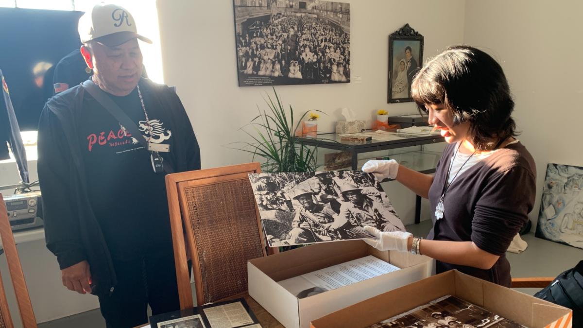 Filipino American Historical Society of Chicago President Ruben Salazar, left, and exhibit curator and FAHSC board member Reese Carolina Cuison Villazor, right, prepare the “Chicago in Quotas and Communities” exhibit at the organization’s museum space in Mana Contemporary on Oct. 16, 2025. (Eunice Alpasan / WTTW News)