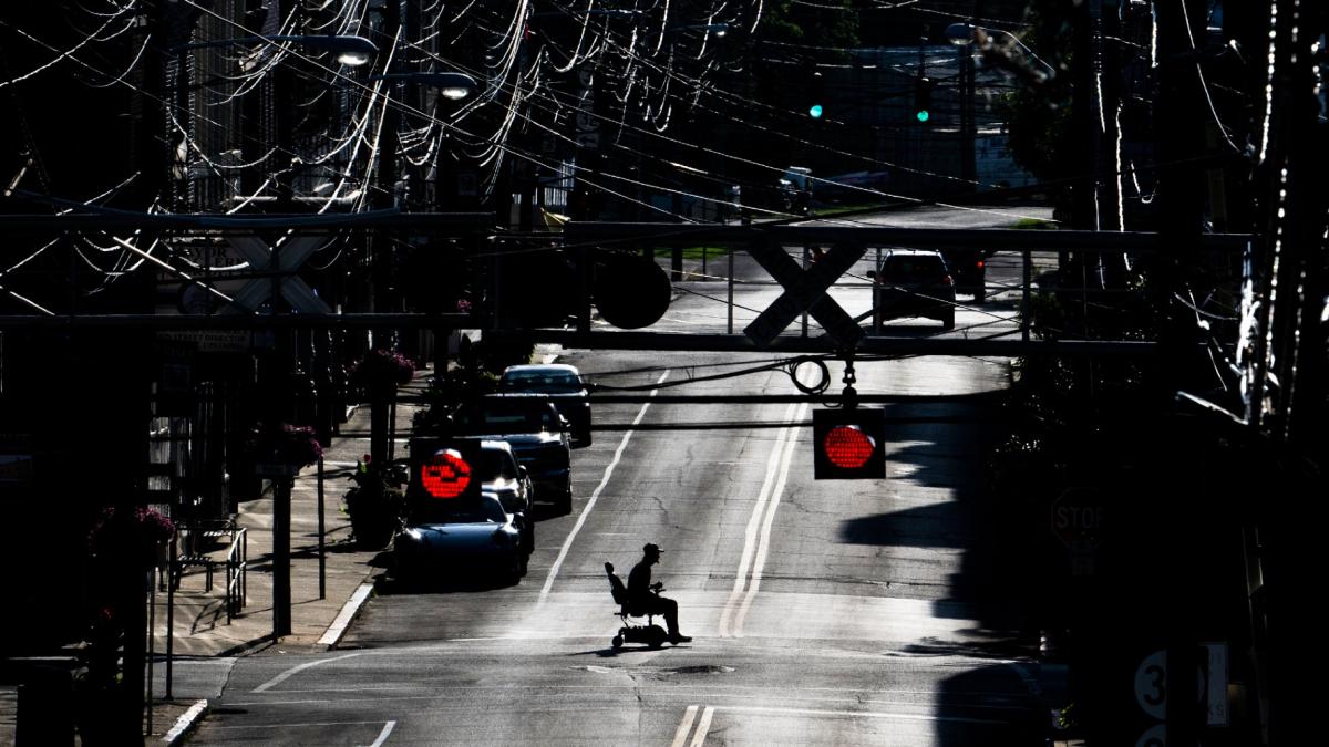 FILE - A man in an electric wheelchair crosses Pike Street in downtown Cynthiana, Ky., on June 23, 2025. (AP Photo / Michael Swensen, File)