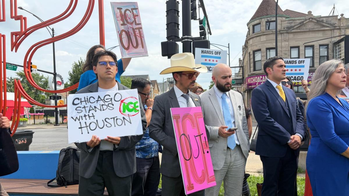 Advocates hold signs during a news conference in the Back of the Yards neighborhood on July 9, 2026, to discuss an increased resurgence in federal immigration enforcement activity in the surrounding area. (Eunice Alpasan / WTTW News)