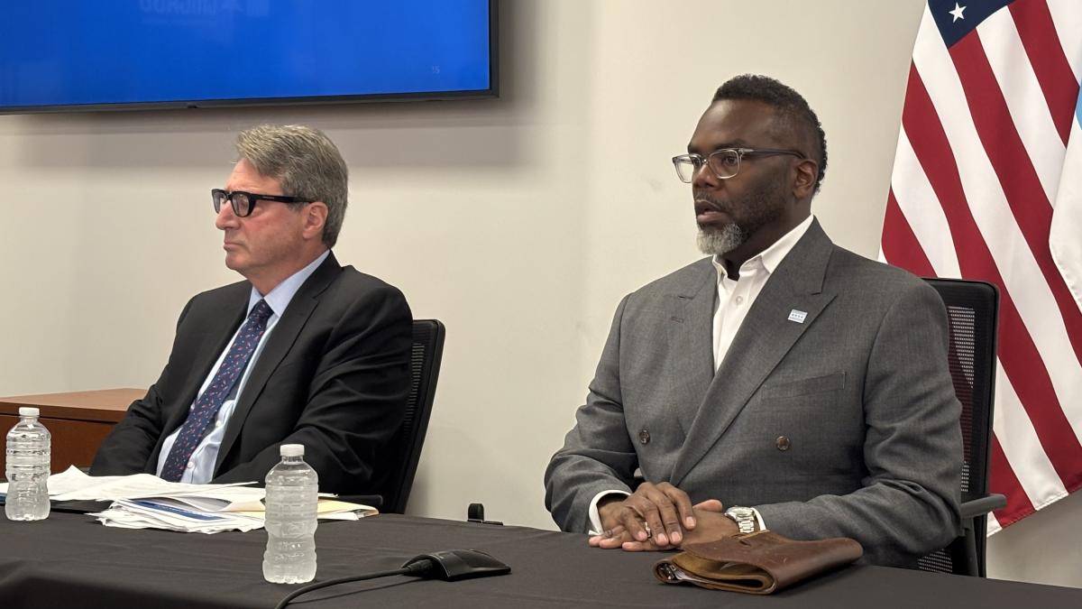 Mayor Brandon Johnson (right), flanked by acting Comptroller Michael Belsky (left), addresses the news media on Tuesday, July 1, 2025. (Heather Cherone / WTTW News)