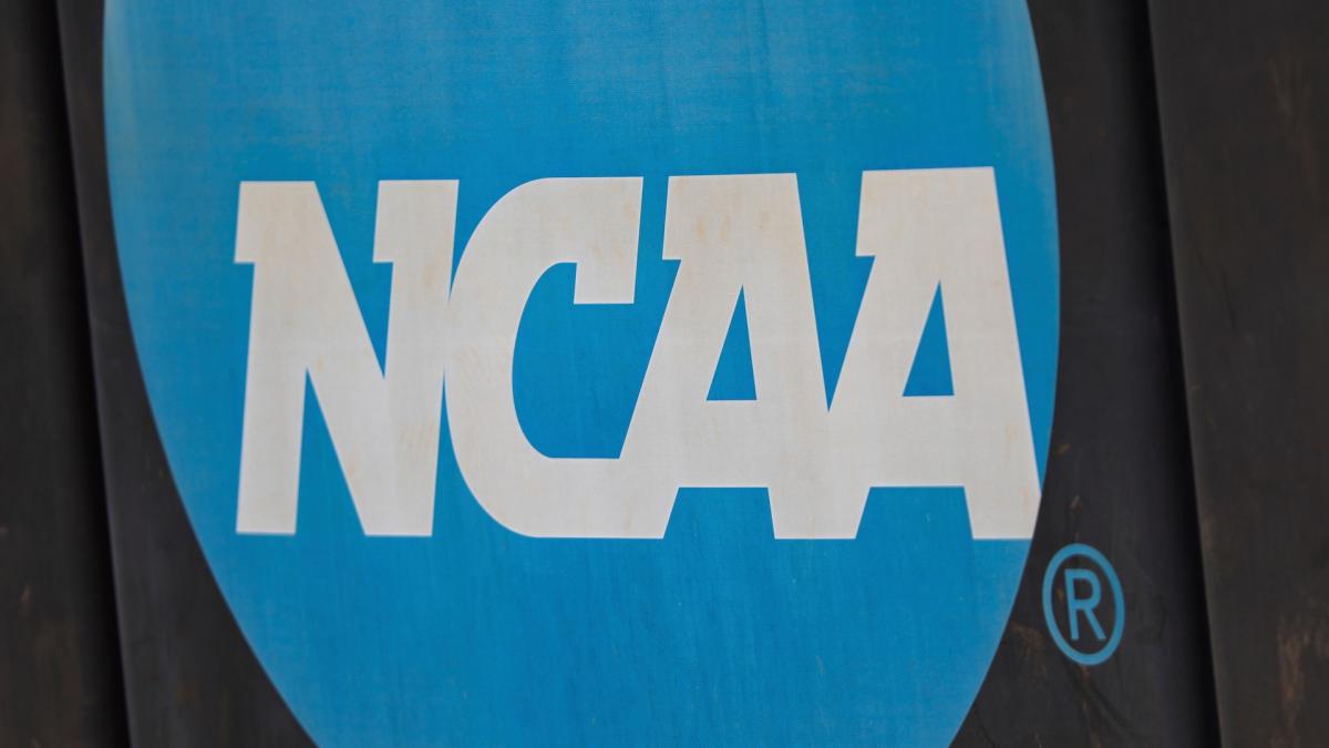 NCAA logo displayed on the fence before an NCAA softball game between Jacksonville and FGCU, March 24, 2024, in Jacksonville, Fla. (AP Photo/Gary McCullough, File)