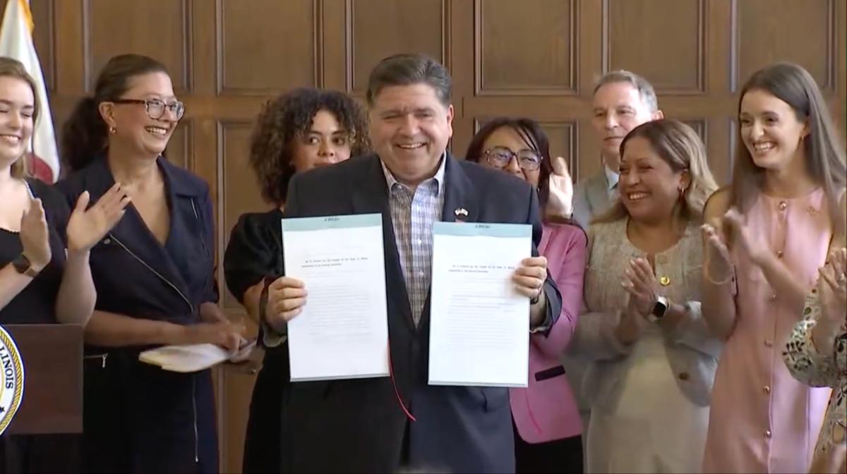 Gov. JB Pritzker signs bills aimed at further protecting reproductive rights in Illinois on Aug. 22, 2025, at the University YMCA in Champaign, Illinois. (Courtesy of state of Illinois live stream)