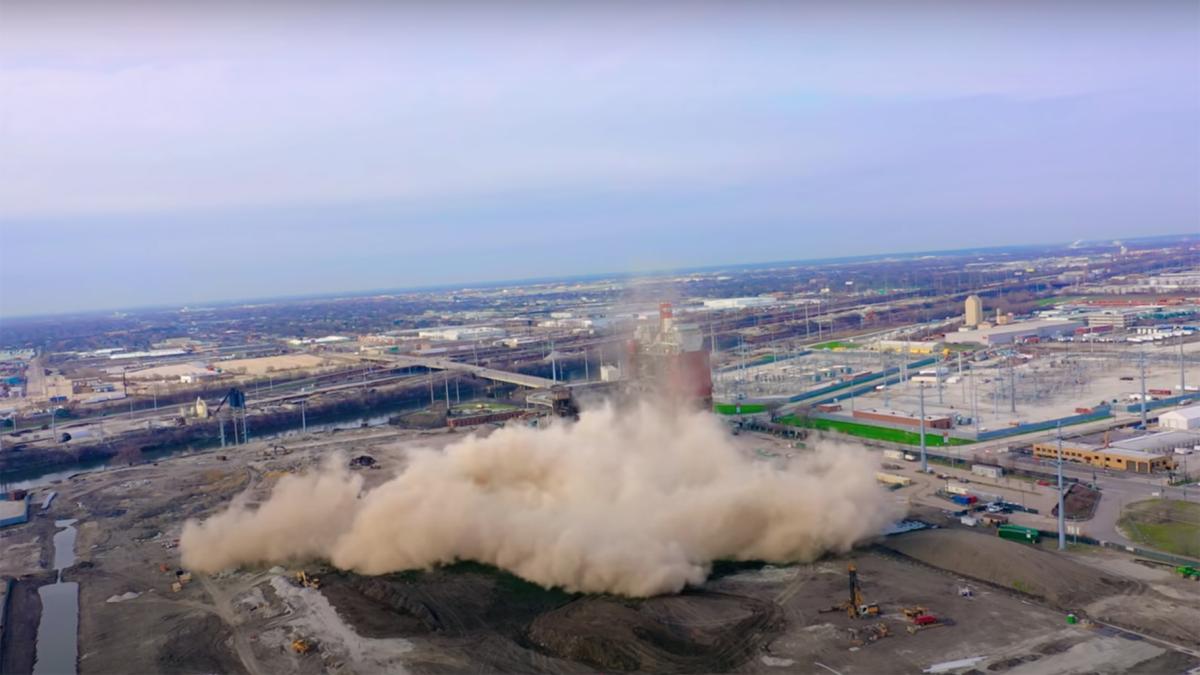 A still image from a video taken of the demolition of the Crawford Coal Plant smokestack, April 11, 2020. (Alejandro Reyes / YouTube) 