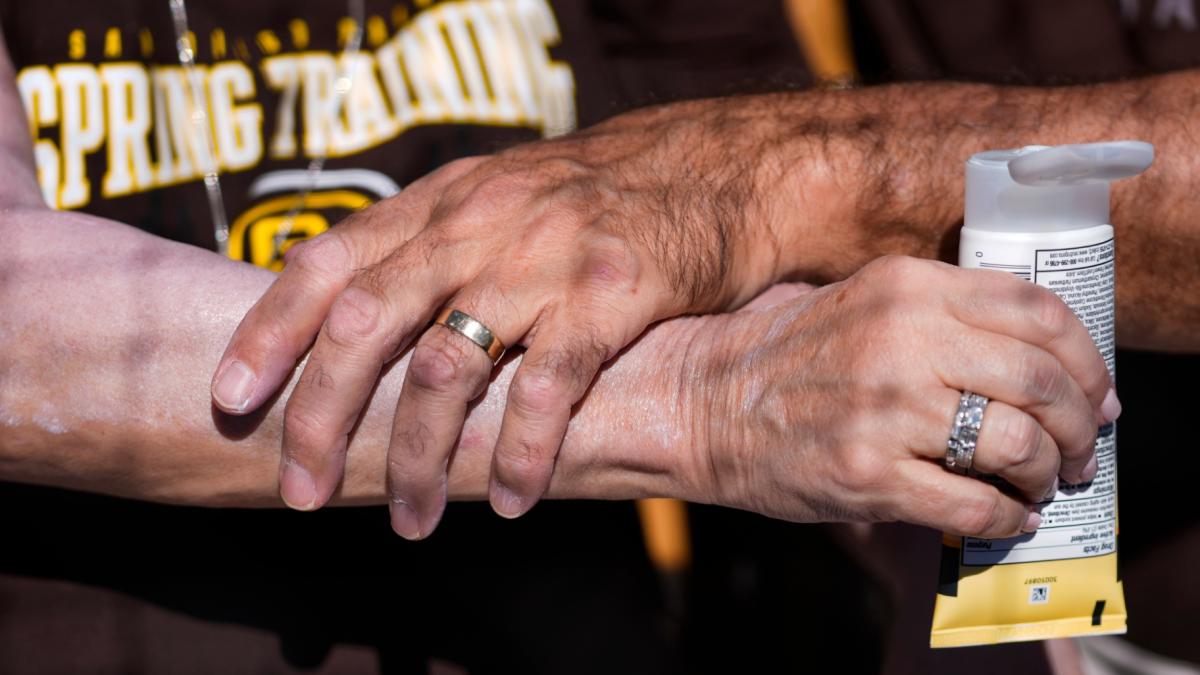 FILE - A man applies sunscreen to a woman's arm before a spring training baseball game between the San Diego Padres and the Chicago White Sox in Phoenix, Feb. 28, 2024. (AP Photo / Ashley Landis, File)