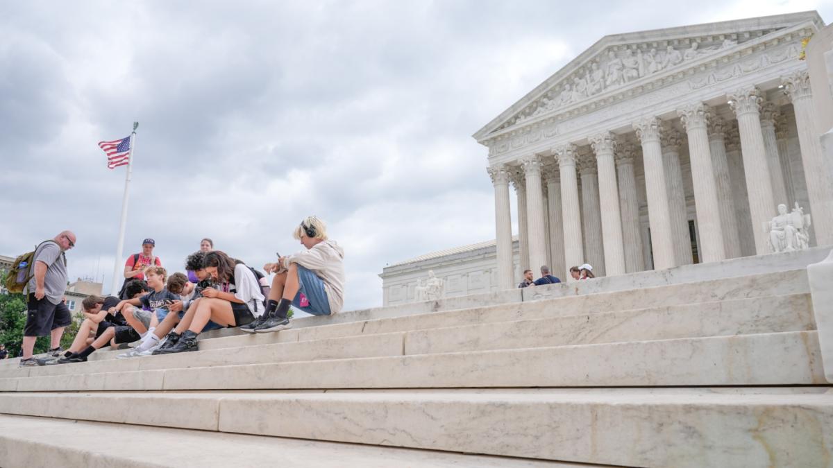 Visitors sit on the steps of the U.S. Supreme Court, Monday, June 8, 2026, in Washington. (AP Photo / Mariam Zuhaib)