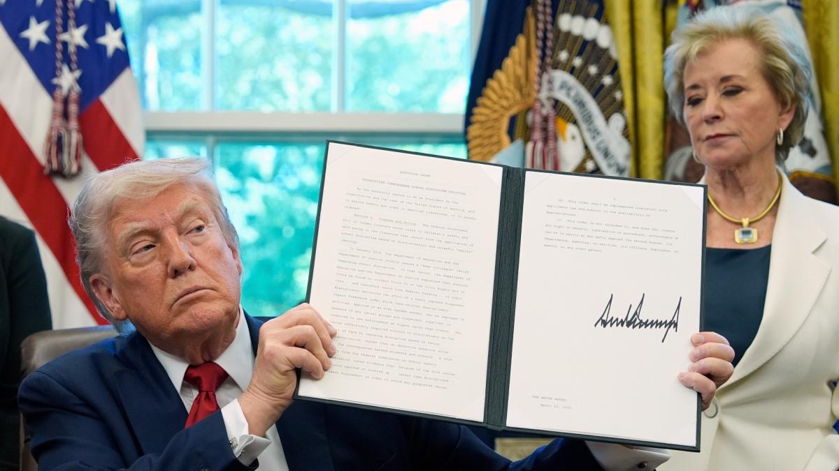 President Donald Trump holds a signed an executive order relating to school discipline policies as Education Secretary Linda McMahon listens in the Oval Office of the White House, Wednesday, April 23, 2025, in Washington. (AP Photo / Alex Brandon)