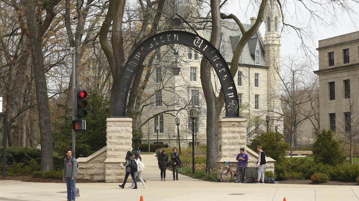 People stand near the entrance gate to Northwestern University in Evanston, Ill., April 29, 2016. (Chris Walker/Chicago Tribune via AP)/Chicago Tribune via AP)