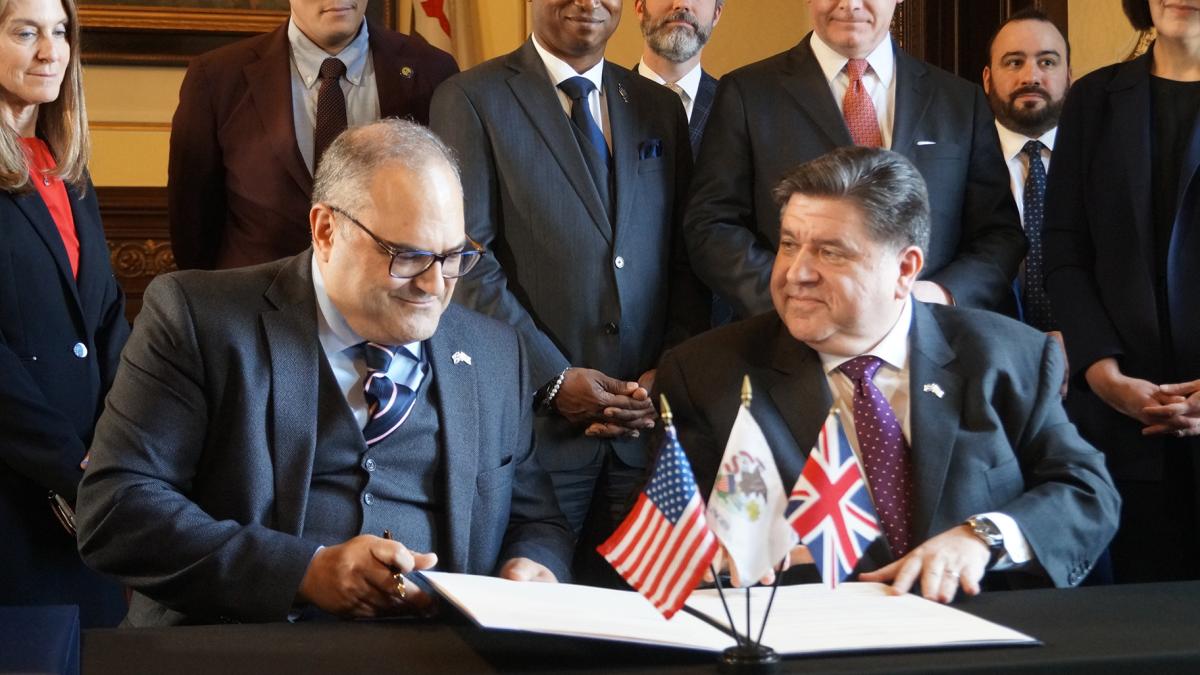U.K. Consul General Richard Hyde, left, and Illinois Gov. J.B. Pritzker sign a memorandum of understanding regarding trade during a ceremony in the governor’s Statehouse office Tuesday, April 8, 2025. (Peter Hancock / Capitol News Illinois)