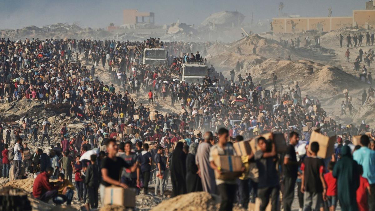 People carry sacks and boxes of food and humanitarian aid that was unloaded from a World Food Program convoy that had been heading to Gaza City in the northern Gaza Strip, June 16, 2025. (AP Photo / Jehad Alshrafi, File)