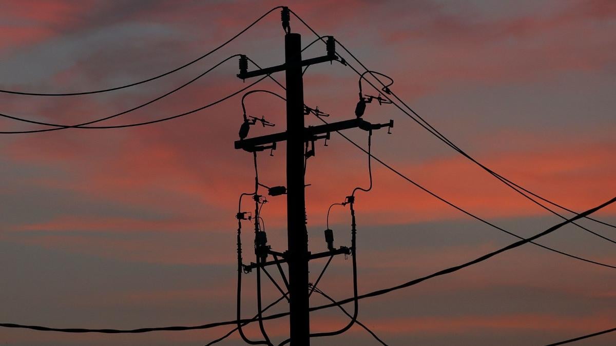 The sun rises behind power cables and telephone lines hang from a utility pole in Houston, Texas, on July 1. 2025. (Aaron M. Sprecher / AP via CNN Newsource)