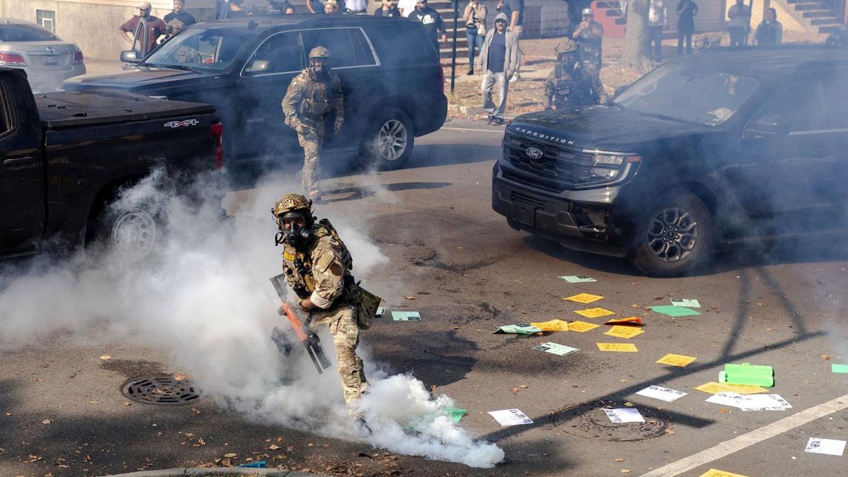 A federal agent prepares to throw a tear gas canister at community members during clashes on Chicago’s South Side on Oct. 14, 2025. (Jim Vondruska / Reuters via CNN Newsource)