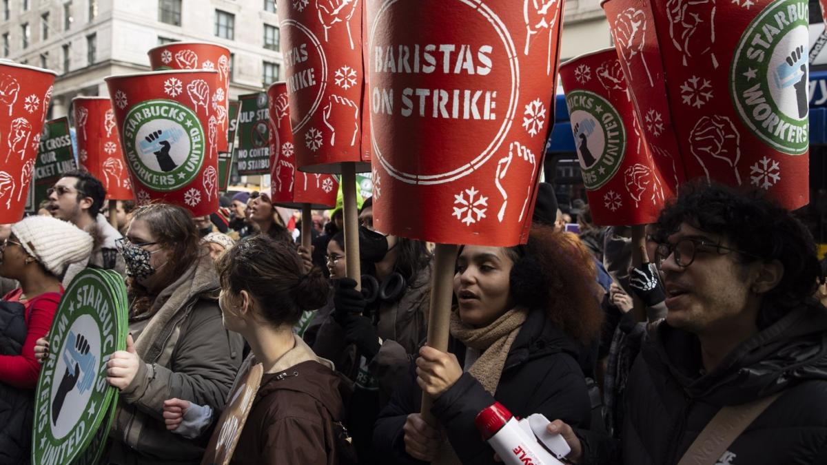 Starbucks workers and supporters picket as part of an open-ended strike pushing for higher wages and improved labor practices outside the Empire State Building Starbucks location in New York City on Dec. 4, 2025. (Mostafa Bassim / Anadolu / Getty Images via CNN Newsource)