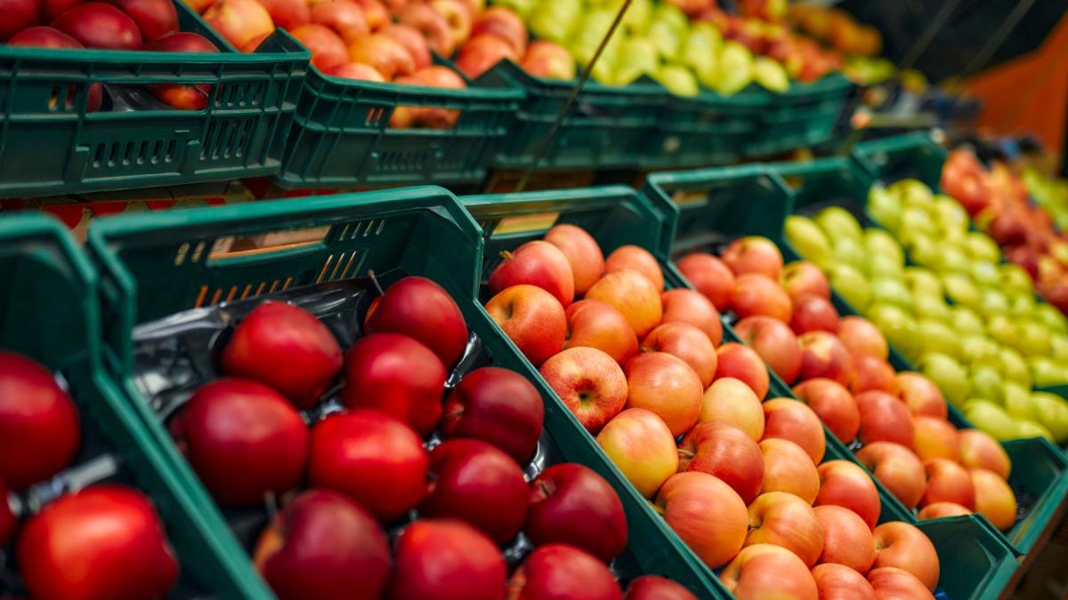 Apples are displayed in a grocery store. (Valerii Apetroaiei / iStock) 