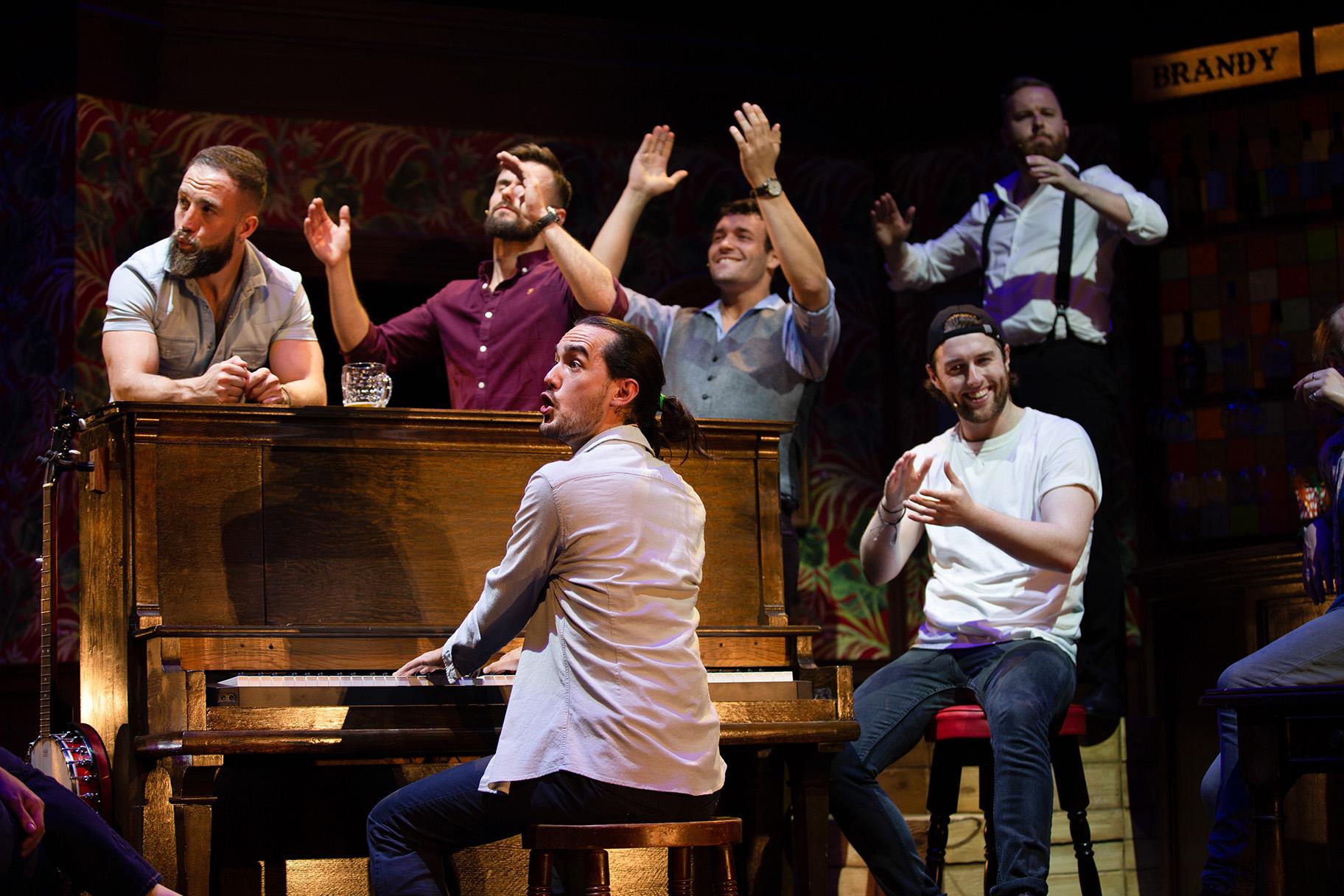 From left: Tom Brandon, John Sheehy, Connor Going (at piano), Andrew Carter, Denis Grinden (seated) and Mark Loveday in “The Choir of Man.” (Credit: Brian Wright)