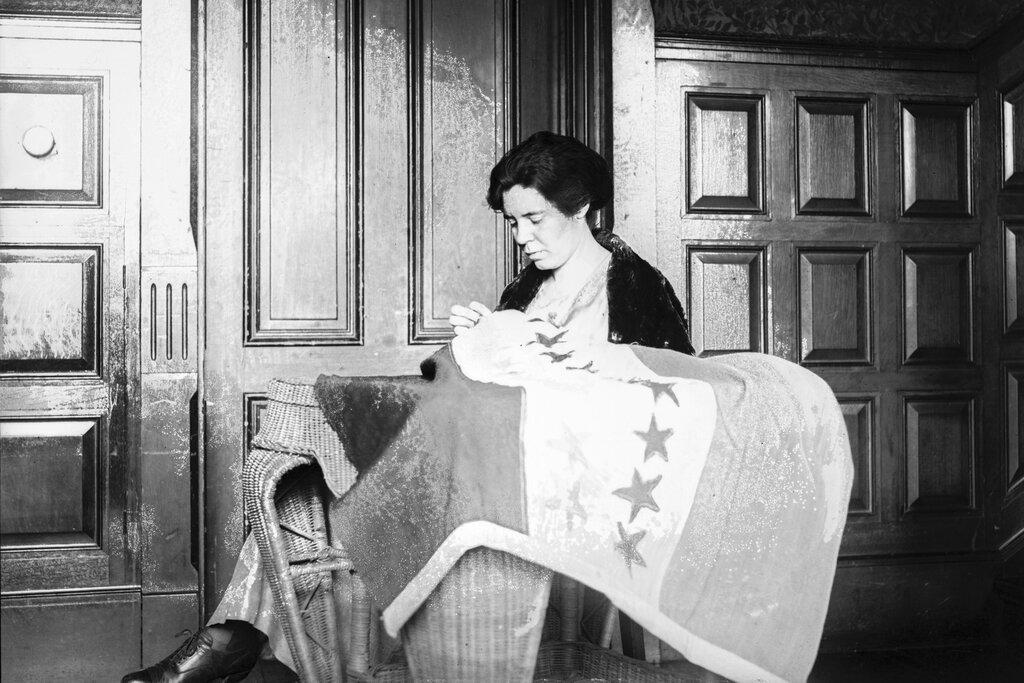 In this 1920s photo, Alice Paul sews a suffrage flag in Washington. One hundred years ago, American women gained the guaranteed right to vote, with ratification of the 19th Amendment. (National Photo Company Collection / Library of Congress via AP)