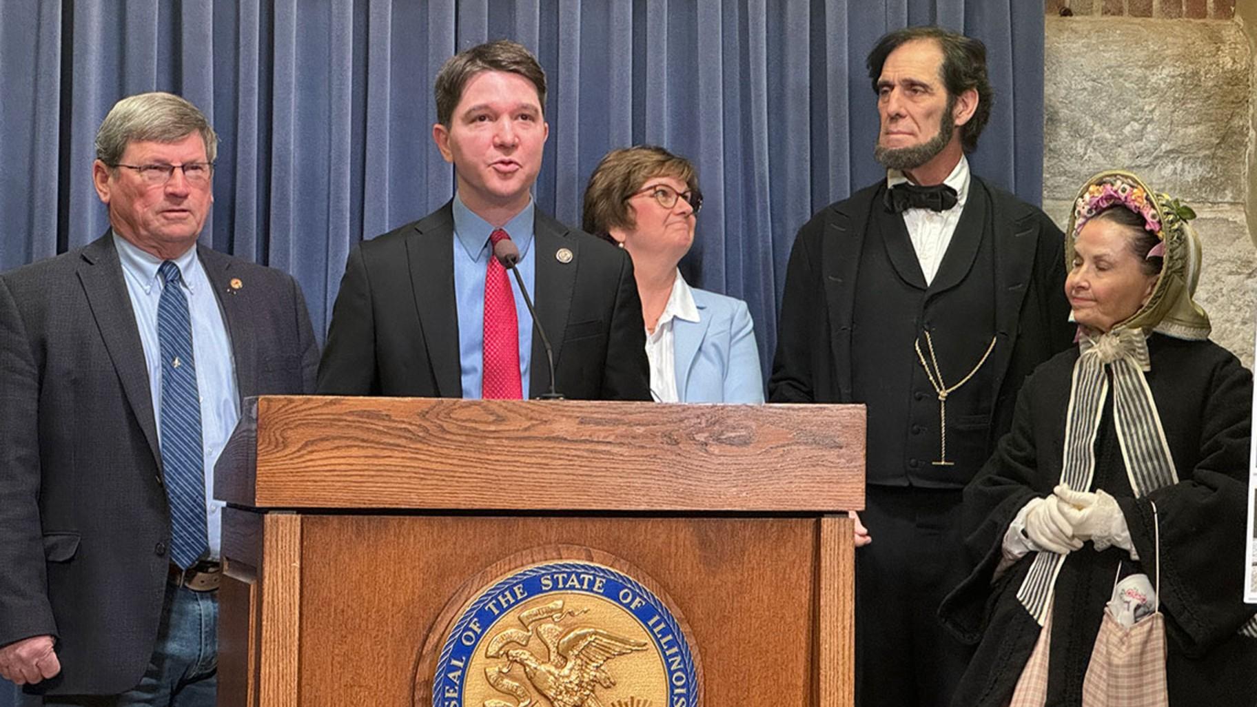 State Sen. Steve McClure speaks at a news conference on Feb. 26, 2025, joined by state Rep. Wayne Rosenthal and New Salem Lincoln League President Gina Gillmore-Wolter and actors portraying Abraham and Mary Todd Lincoln. (Athan Yanos / Medill Illinois News Bureau)